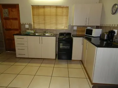 a small kitchen with a sink and a dishwasher at Impalas Walk in Marloth Park