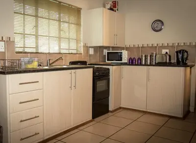 a kitchen with a sink and a stove top oven at Impalas Walk in Marloth Park