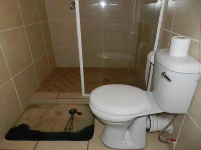 a bathroom with a white toilet and a shower at Impalas Walk in Marloth Park