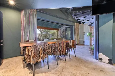 a room with a bar with wooden tables and chairs at Veranda House Boutique Accommodation in Midrand