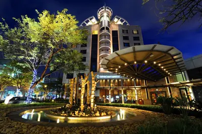 a building with a fountain in front of it at night at InterContinental Johannesburg OR Tambo Airport Hotel by IHG in Kempton Park