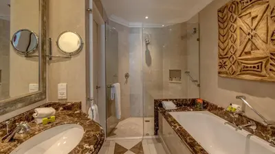 a bathroom with a large tub and a shower at InterContinental Johannesburg OR Tambo Airport Hotel by IHG in Kempton Park