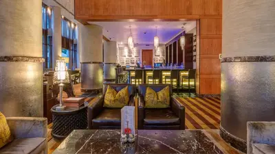a bar at a hotel with leather chairs and tables at InterContinental Johannesburg OR Tambo Airport Hotel by IHG in Kempton Park