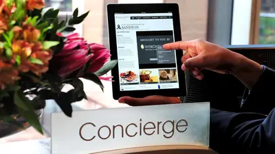 a person holding a cell phone with a cancer website at InterContinental Johannesburg OR Tambo Airport Hotel by IHG in Kempton Park