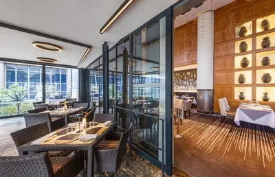 a dining room with tables and chairs and windows at InterContinental Johannesburg OR Tambo Airport Hotel by IHG in Kempton Park