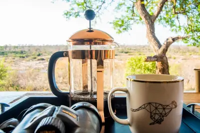 a blender sitting on a table next to a coffee cup at MANZINI RIVER HOUSE - Mjejane Private Game Reserve, Greater Kruger National Park in Hectorspruit