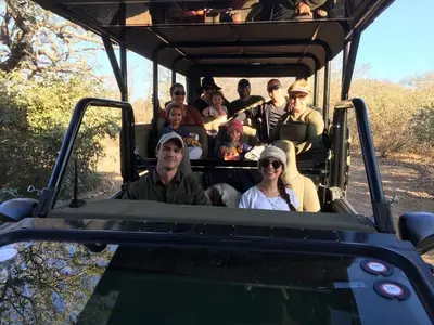 a group of people riding in the back of a safari vehicle at MANZINI RIVER HOUSE - Mjejane Private Game Reserve, Greater Kruger National Park in Hectorspruit