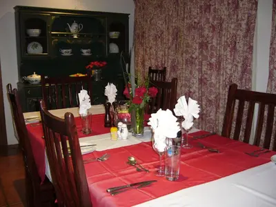 a dining room table with a red table cloth at Nooitgedacht Trout Lodge in Lydenburg