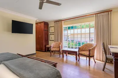 a bedroom with a bed and a table and chairs at Protea Hotel by Marriott Polokwane Ranch Resort in Polokwane