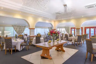 a dining room with tables and chairs and flowers on it at Protea Hotel by Marriott Polokwane Ranch Resort in Polokwane