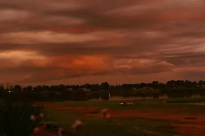 a storm cloud over a field with a horse in a field at Bottom of Boden in Benoni