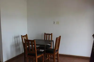 a table and chairs in a room with a white wall at Bottom of Boden in Benoni