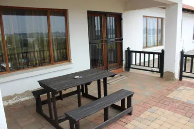 a wooden table and bench in front of a building at Bottom of Boden in Benoni
