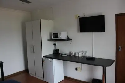 a small kitchen with a table and a microwave at Bottom of Boden in Benoni