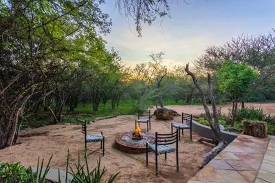 a group of chairs sitting around a fire pit at The Bush House in Hoedspruit