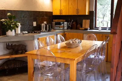 a wooden table and chairs in a kitchen at Zebra Lodge in Hoedspruit