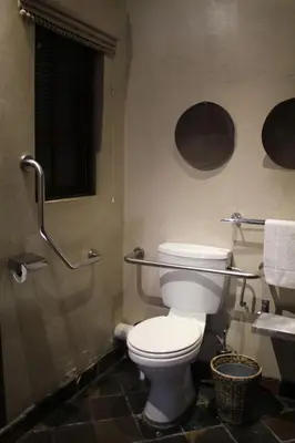 a bathroom with a toilet and a window and towels at Mosate Lodge in Polokwane