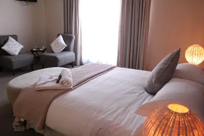 a bedroom with a white bed with shark pillows on it at Mosate Lodge in Polokwane