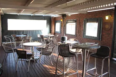 a room with tables and chairs and a projection screen at Mosate Lodge in Polokwane