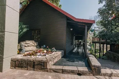 a building with a flower bed in front of it at Beetleloop Guest House in Nelspruit