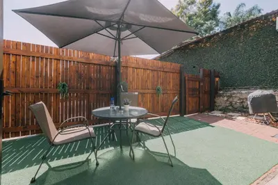 a table and chairs with an umbrella on a patio at Beetleloop Guest House in Nelspruit