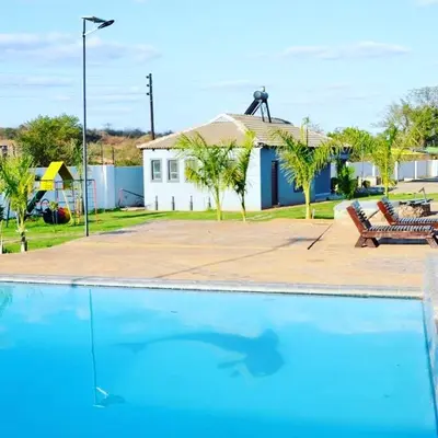 a swimming pool in front of a house at 1 OAK Resort in Thohoyandou