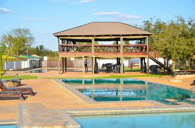 a gazebo with a swimming pool and a house at 1 OAK Resort in Thohoyandou