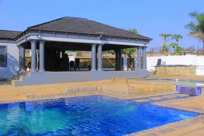 a swimming pool in front of a house at 1 OAK Resort in Thohoyandou