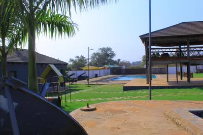 a park with a playground with a slide and a pool at 1 OAK Resort in Thohoyandou