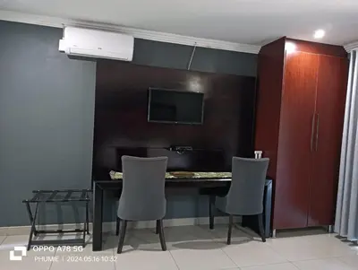 a dining room with a table and chairs and a tv at 1 OAK Resort in Thohoyandou