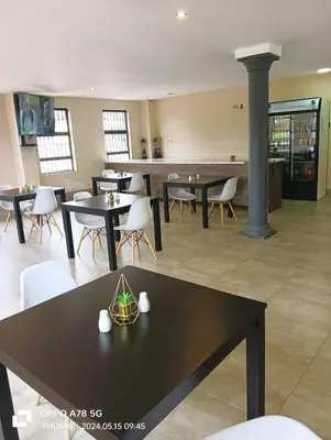 a dining room with tables and white chairs at 1 OAK Resort in Thohoyandou