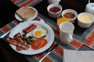 a plate of breakfast food with eggs sausage and tomatoes at Lions Place in Grietjie Nature Reserve