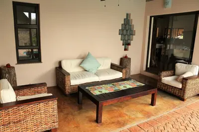 a living room with wicker chairs and a coffee table at Lions Place in Grietjie Nature Reserve