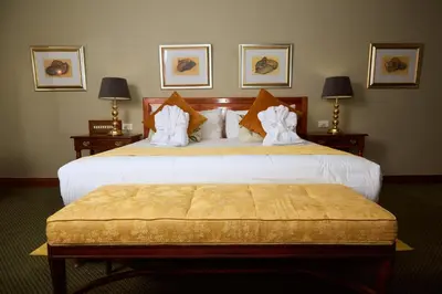 a hotel room with two beds with white sheets at Coach House Hotel & Spa Tzaneen in Tzaneen