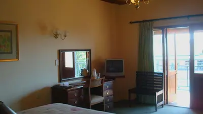 a bedroom with a desk and a mirror and a dresser at Magoebaskloof Hotel in Tzaneen