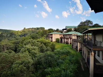 a row of apartment buildings with trees and bushes at Magoebaskloof Hotel in Tzaneen