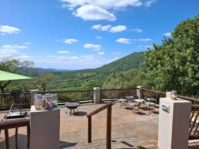 a patio with a view of the mountains at Chestnut Country Lodge in Hazyview