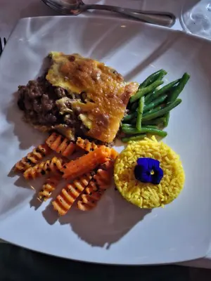 a plate of food with meat and vegetables on it at Chestnut Country Lodge in Hazyview