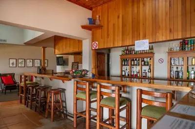 a bar with wooden stools in a restaurant at Chestnut Country Lodge in Hazyview