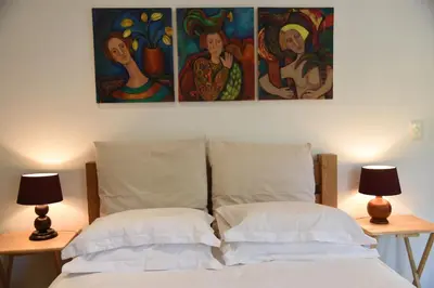 a bedroom with two pillows and a painting on the wall at Molly's Cottage in Graskop