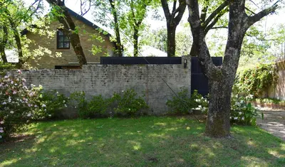 a brick retaining wall in front of a house at Molly's Cottage in Graskop