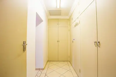 a bathroom with white cabinets and a walk in shower at LeoZet Self catering apartment in Pretoria