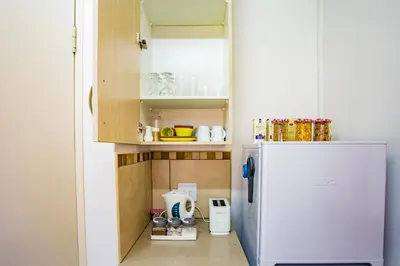 a small kitchen with a white refrigerator at LeoZet Self catering apartment in Pretoria