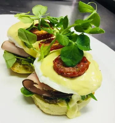 two sandwiches with meat and greens on a white plate at Ivory Manor Boutique Hotel in Pretoria