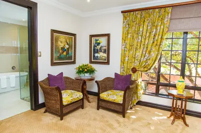 a living room with two chairs and a window at Ivory Manor Boutique Hotel in Pretoria