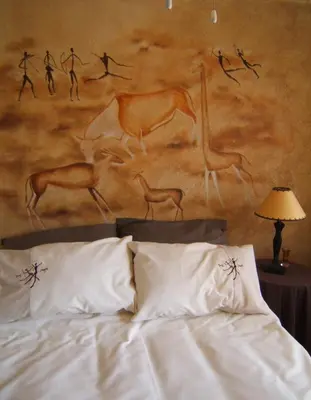 a bedroom with a bed with a painting on the wall at Vivian's Cottage in Pretoria