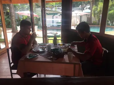 two men sitting at a table in a restaurant at Villa Grande Lodge in Louis Trichardt