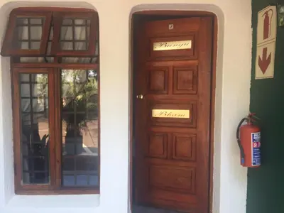 two wooden doors on a building at Villa Grande Lodge in Louis Trichardt