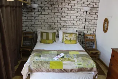 a bedroom with a bed and a brick wall at Grace Accommodation Centurion in Centurion