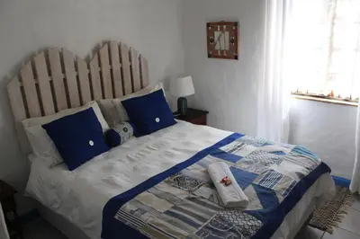 a bedroom with a large bed with blue pillows at Grace Accommodation Centurion in Centurion